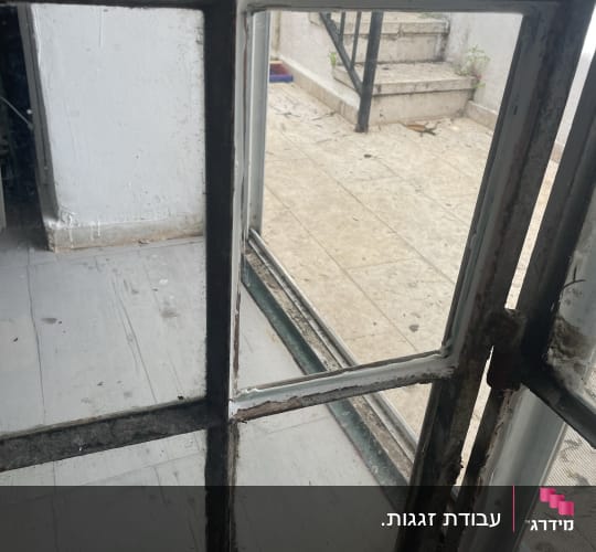 חלון זכוכית עם מסגרת מתכת חלודה